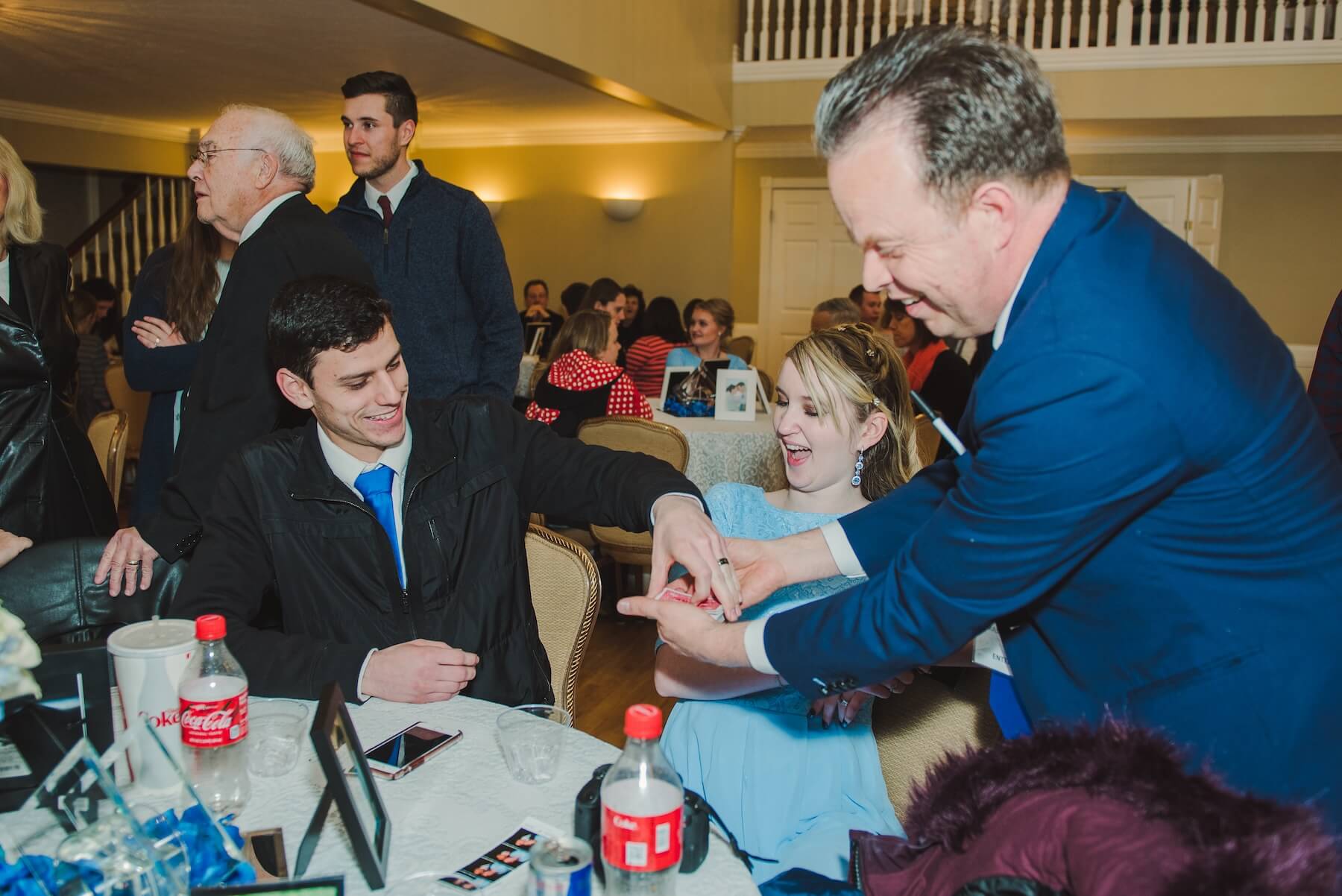 Young Couple at table smiling at card trick.